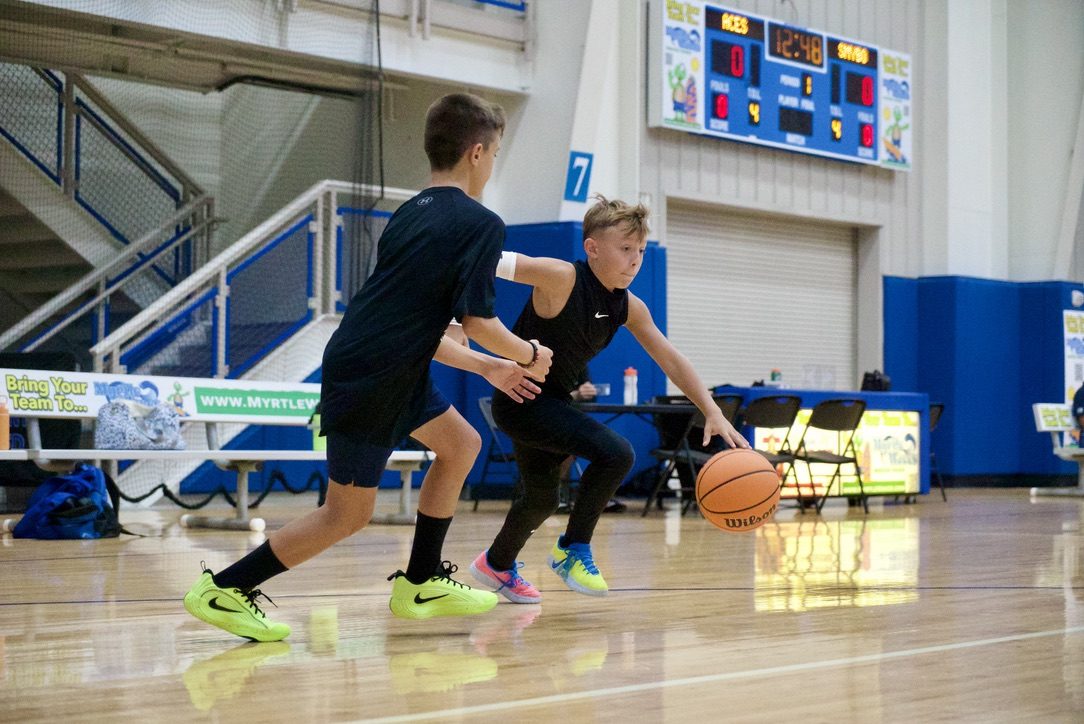 Two young players going one-on-one at a Myrtle Beach Basketball Academy game